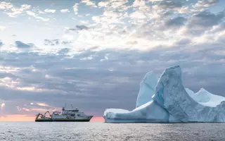 Le Pourquoi pas ? à gauche et à droite, en face, un Iceberg, vue de la mer du coté droit du navire