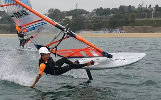 Un planchiste, sa planche à voile et son foil dans la rade de Brest