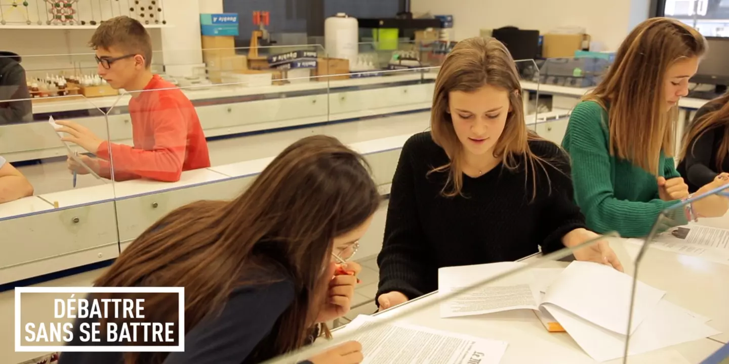 Des élèves de Lycée regardent des documents sur un bureau los d'une séance de travail sur le projet de médiation de l'Ifremer "Débattre sans se battre".