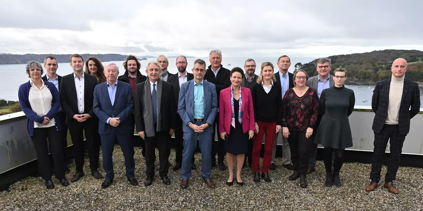 Photo de groupe du comité des parties prenantes sur le toit d'un bateau, avec la mer en arrière plan.