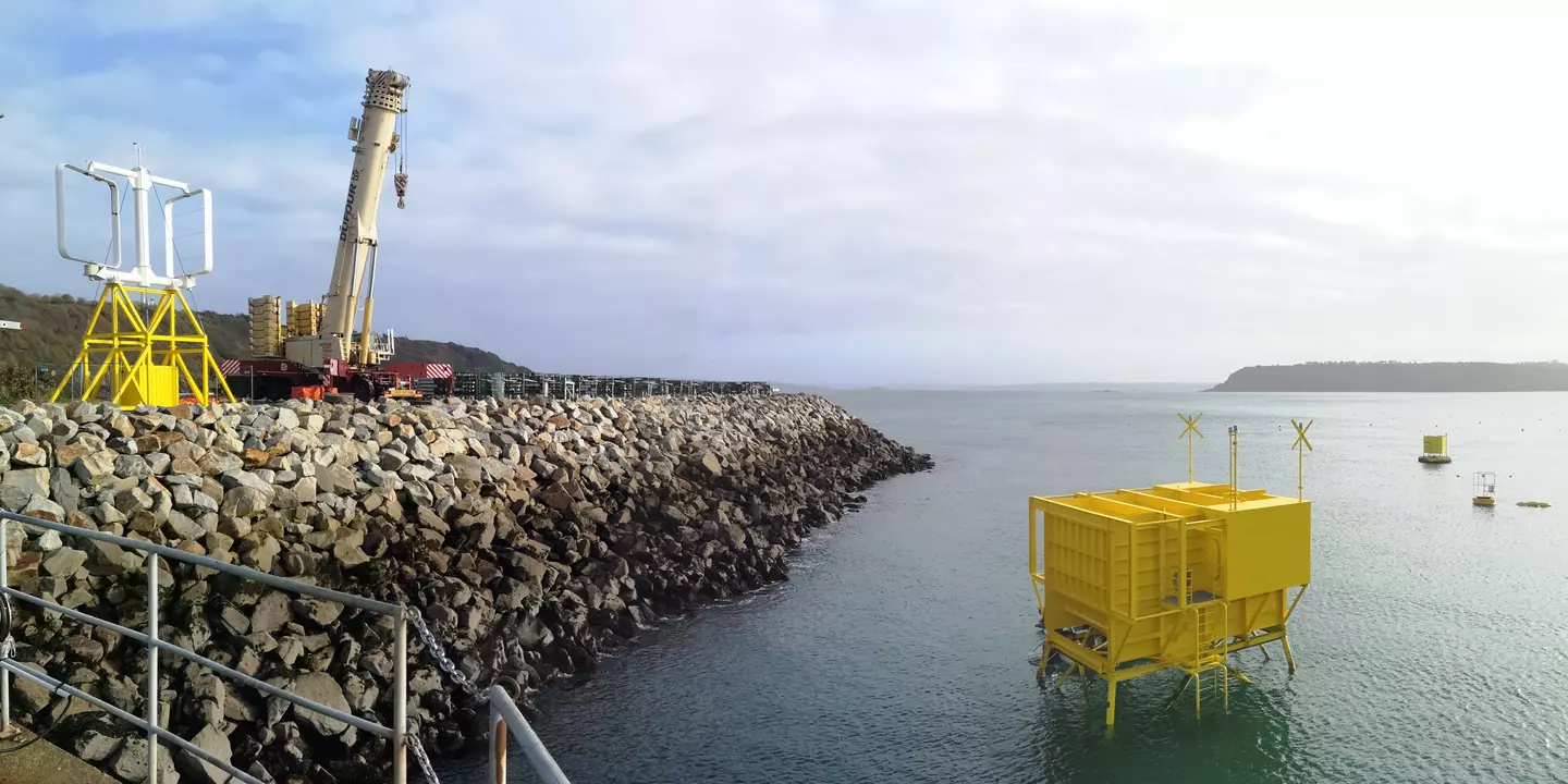 Grand cube jaune. Élément placé devant une digue de port.