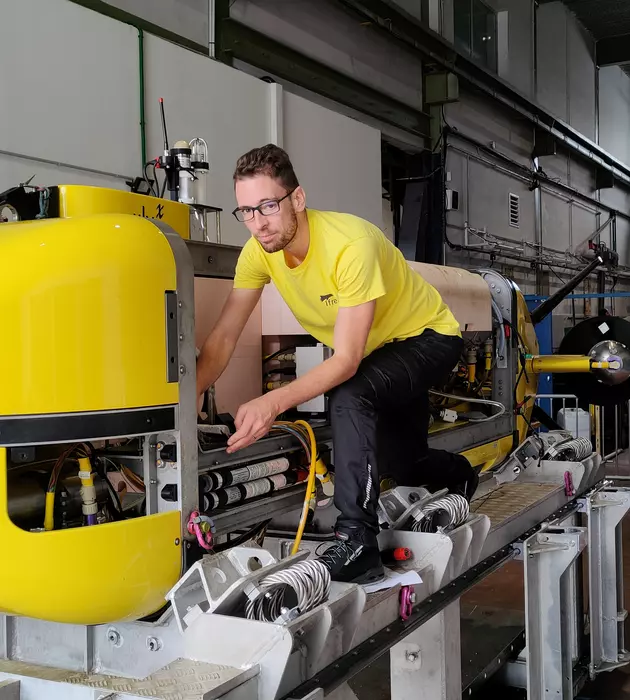 Homme qui travail sur un engin dans un atelier.