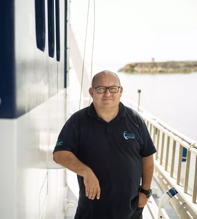 Homme debout le long du bateau.