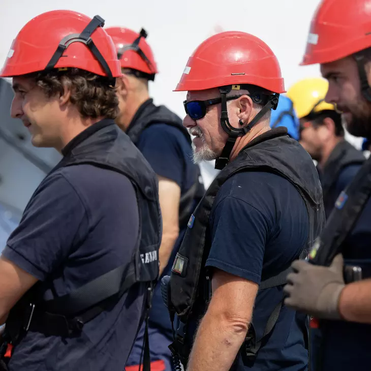 Quatre personnes équipés d'un casque rouge et d'un gilet de sauvetage.