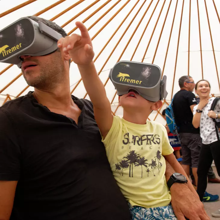 Festival Lumexplore : animation Ifremer 3D. Un adulte et un enfant avec un casque de réalité virtuelle sur les yeux.