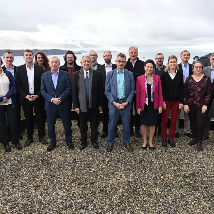 Photo de groupe du comité des parties prenantes sur le toit d'un bateau, avec la mer en arrière plan.