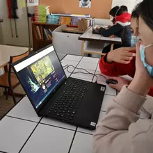 Élèves devant un ordinateur dans une salle de classe.